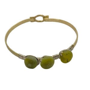 Gold tone thin bracelet with green stones